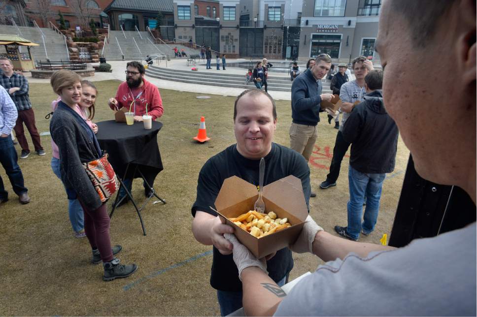 Scott Sommerdorf | The Salt Lake Tribune
A customer comes to get an order of poutine from the one of the food trucks at The Gateway on  Wednesday, March 8, 2017, during "Food Trucks at the Fountain." The Gateway  is expanding the program to five days a week beginning Monday, March 20.