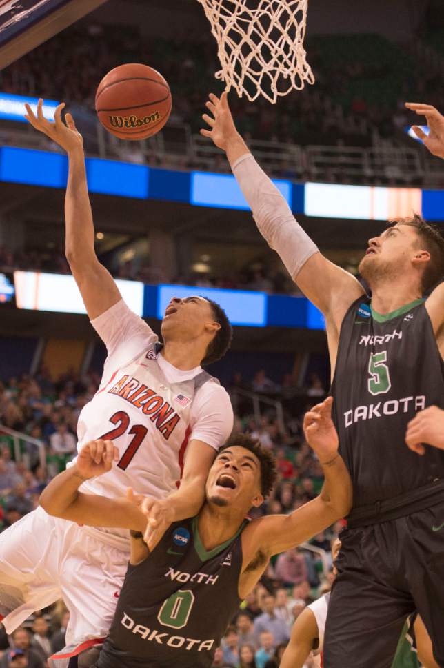 Trent Nelson  |  The Salt Lake Tribune

Arizona Wildcats center Chance Comanche (21) collides with North Dakota Fighting Sioux guard Geno Crandall (0) during the first round of the NCAA Tournament in Salt Lake City on Thursday, March 16, 2017.