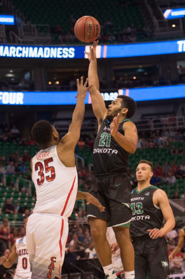 Chris Detrick  |  The Salt Lake Tribune

North Dakota Fighting Sioux guard Quinton Hooker (21) shoots over Arizona Wildcats guard Allonzo Trier (35) during the first round of the NCAA Tournament in Salt Lake City on Thursday, March 16, 2017.