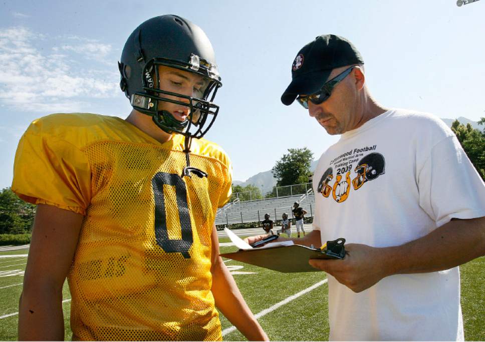 Scott Sommerdorf  l  The Salt Lake Tribune

Cottonwood High football coach Scott Cate calls the next play for his QB Cooper Bateman (left) to run during practice in Murray on Thursday, August 12, 2010.