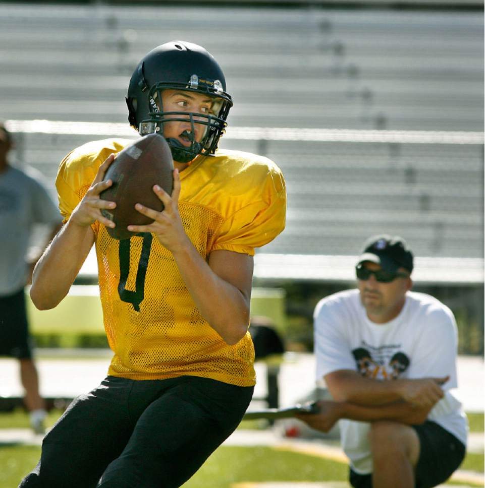 Scott Sommerdorf  l  The Salt Lake Tribune

Cottonwood High football coach Scott Cate (right) watches as his QB Cooper Bateman drops back during practice in Murray on Thursday, August 12, 2010.