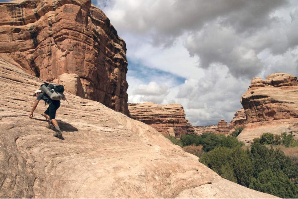Al Hartmann  |  The Salt Lake Tribune 
Backpacker climbs a sandstone ramp in a canyon on Cedar Mesa in a part of San Juan County that is now Bears Ears National Monument.
