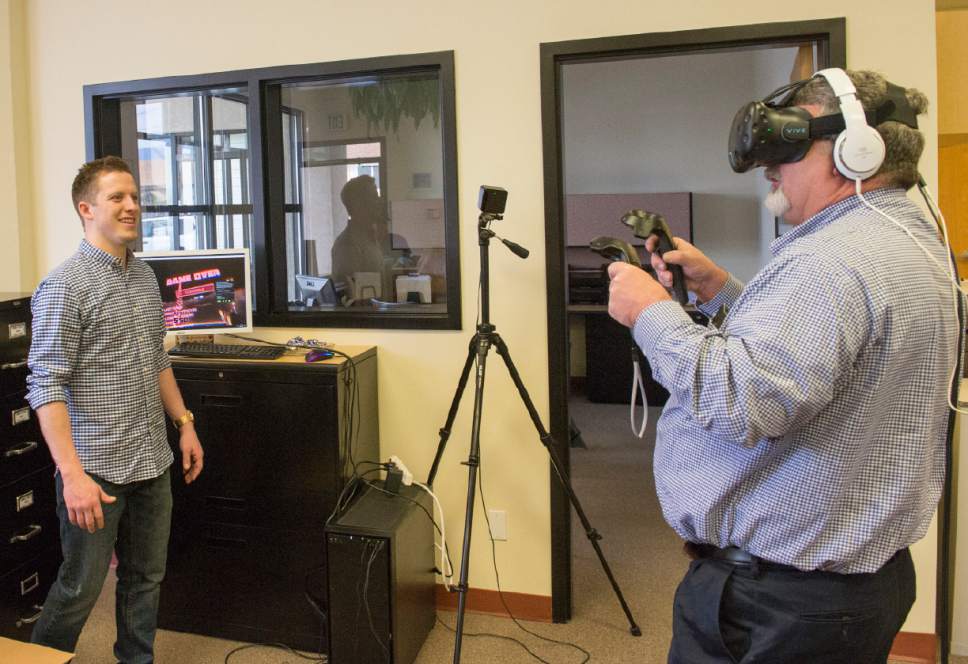 Rick Egan  |  The Salt Lake Tribune

Dallin Funk, from Virtualities, helps Jim Herrin get set up to play a virtual reality game, at the opening of The Utah Microenterprise Loan Fund client support center to help the success rate of the small businesses that have received its loans. Wednesday, March 22, 2017.