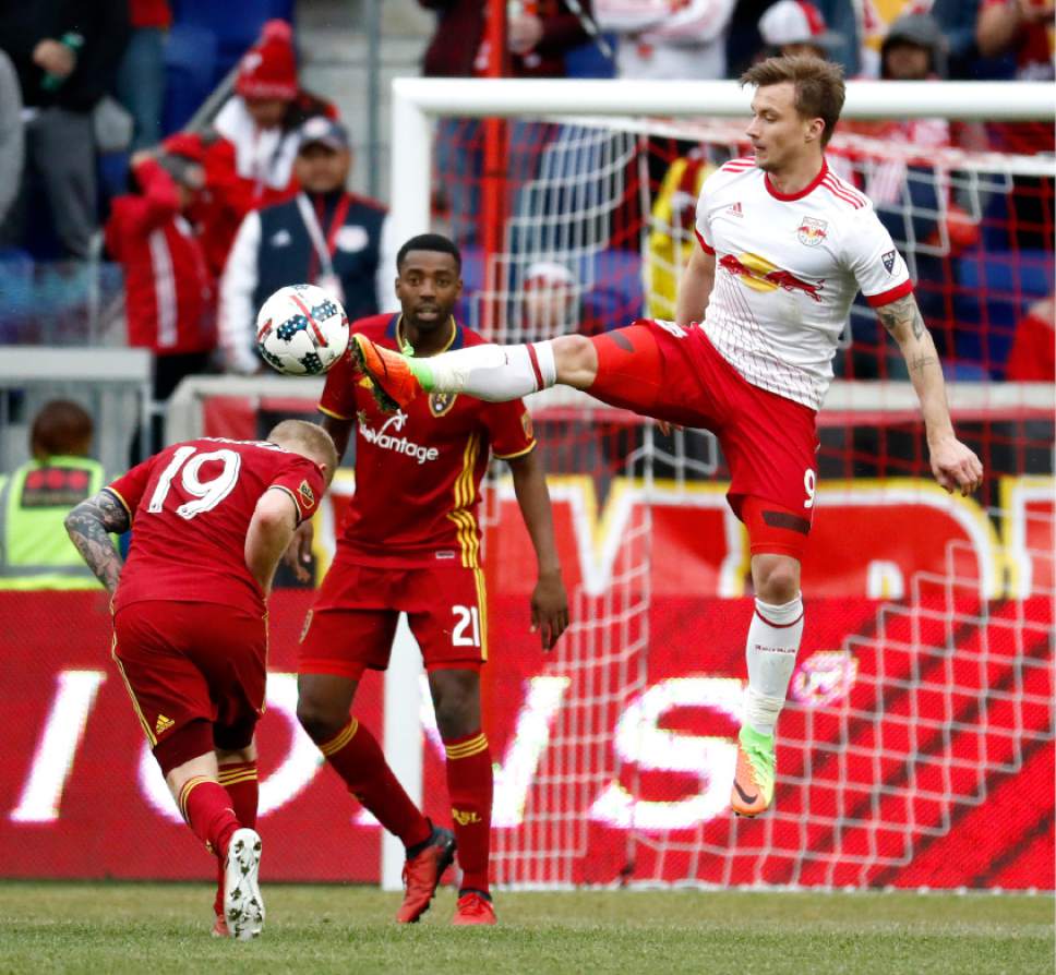 New York Red Bulls forward Fredrik Gulbrandsen, right, tries to get a foot on the ball as Real Salt Lake midfielder Luke Mulholland (19) avoids the kick during the second half of an MLS soccer match, Saturday, March 25, 2017, in Harrison, N.J. (AP Photo/Julio Cortez)