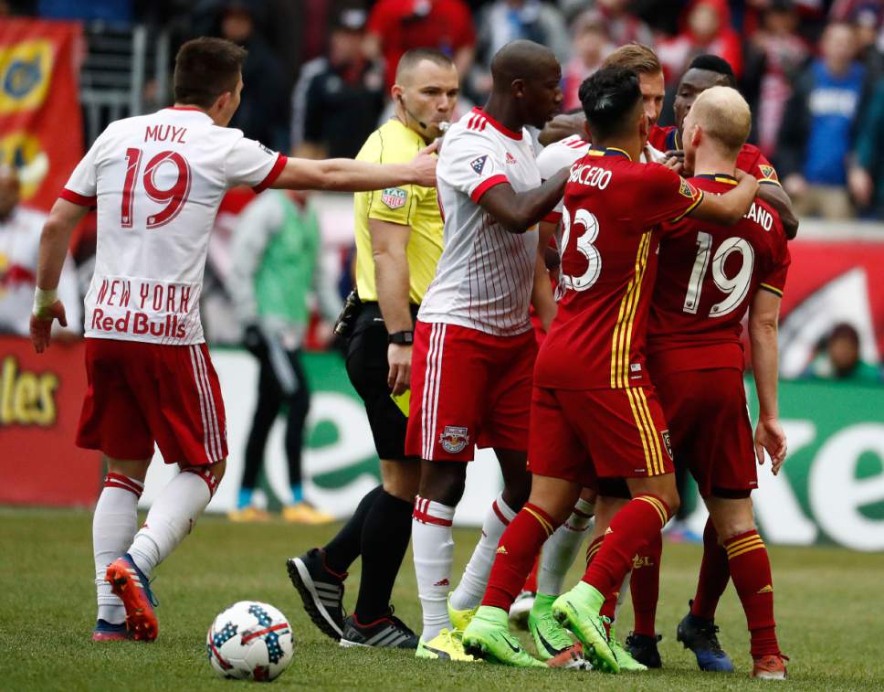 Real Salt Lake midfielder Luke Mulholland (19) and New York Red Bulls midfielder Daniel Royer, back right, argue as teammates try to break them up during the second half of an MLS soccer match, Saturday, March 25, 2017, in Harrison, N.J. The teams tied 0-0. (AP Photo/Julio Cortez)