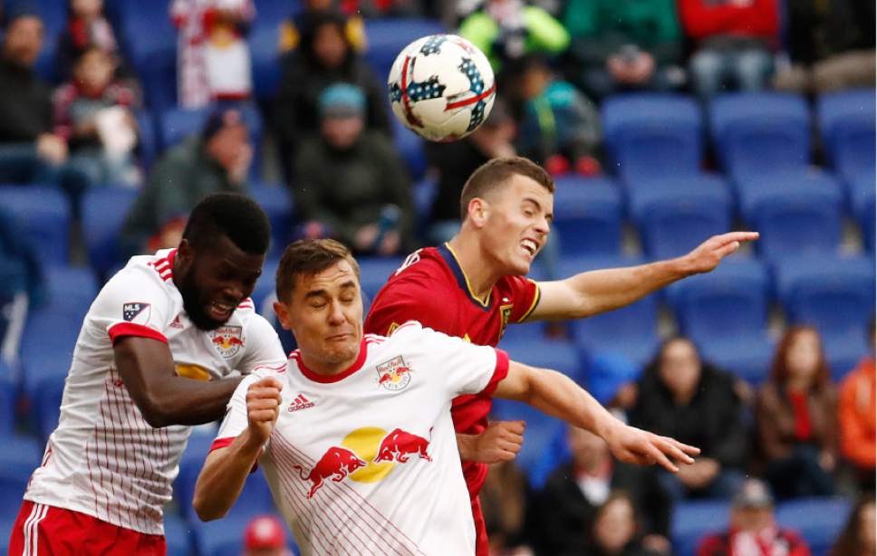 New York Red Bulls defender Kemar Lawrence, left, and teammate midfielder Aaron Long, center, go up for the ball against Real Salt Lake forward Brooks Lennon during the second half of an MLS soccer match, Saturday, March 25, 2017, in Harrison, N.J. (AP Photo/Julio Cortez)