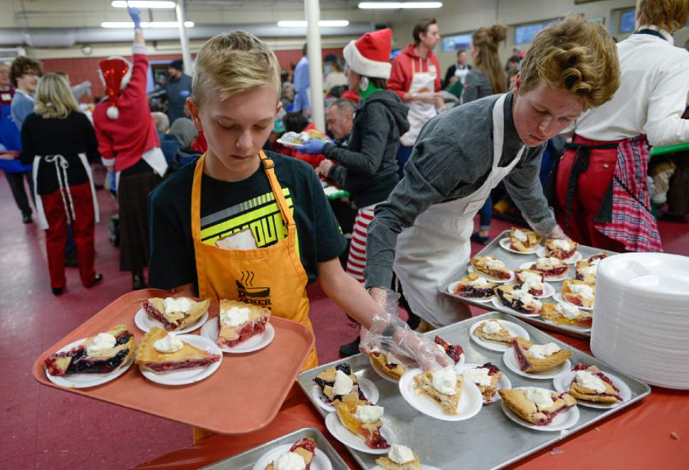 Francisco Kjolseth | The Salt Lake Tribune
Soren Mickelson, 12, left, and Cody Wright, 18, fill up trays with dessert as volunteers and other community leaders serve the annual Christmas dinner to more than 800 homeless Utahns Friday at St. Vincent de Paul Dining Hall in downtown Salt Lake City.