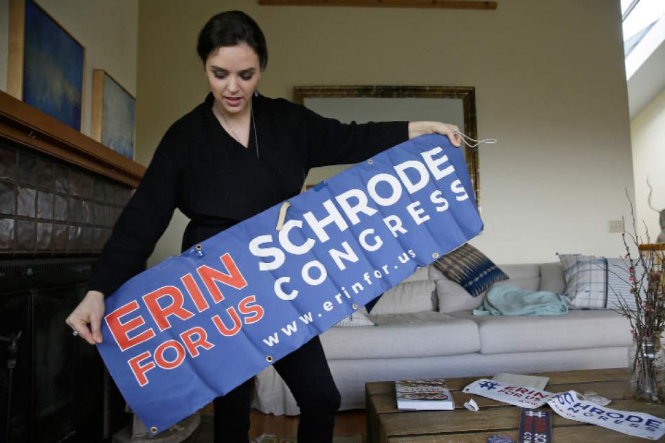 In this Feb. 21, 2017, photo, Erin Schrode unfurls a campaign banner at her home in Mill Valley, Calif. Less than a week before the election for her long-shot congressional campaign, Schrode woke up in her northern California home, rolled over in bed and reflexively checked her cellphone. The 25-year-old activist burst into tears when she found a barrage of anti-Semitic emails. (AP Photo/Eric Risberg)