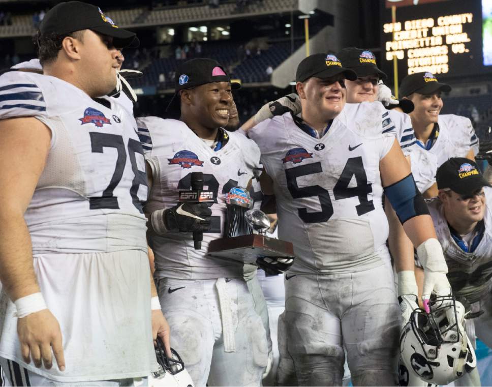 Rick Egan  |  The Salt Lake Tribune

Brigham Young Cougars running back Jamaal Williams (21) stands with offensive lineman, Tuni Kanuch (78), and Parker Dawe (54) after he was presented the trophy for offensive MVP, in the Poinsettia Bowl, at Qualcomm Stadium in San Diego, December 21, 2016.
