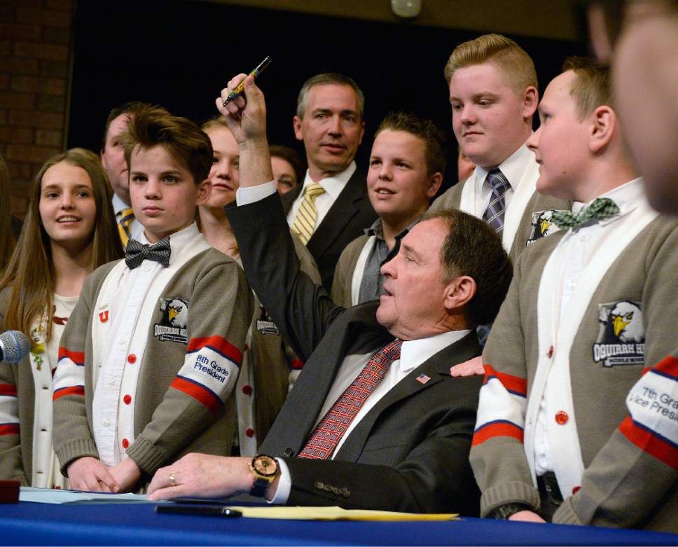 Al Hartmann  |  The Salt Lake Tribune
Gov. Gary Herbert signs a series of education bills passed by this year's legislative session in front of students body officers at Oquirrh Hills Middle School in Riverton Wednesday March 29.