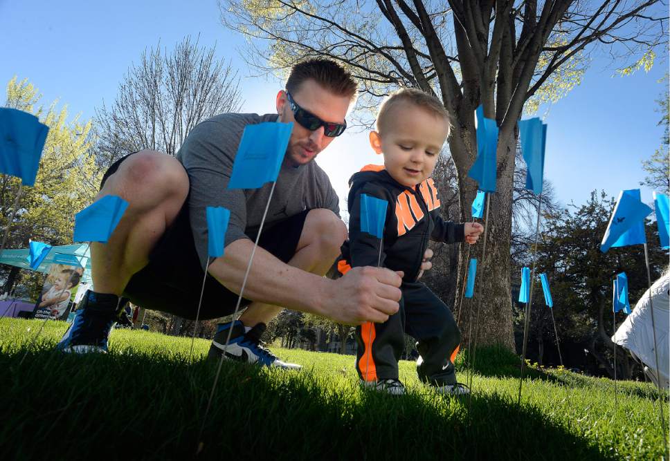 Scott Sommerdorf | The Salt Lake Tribune
Ben Anderson and his son Kemp, helped the Carmen B Pingree Autism Center of Learning to place some of the 16,000 blue flags on the lawn at Washington Square Park, Saturday, April 1 2017. The flags represent the 1 in 58 children in Utah who will be diagnosed with autism.