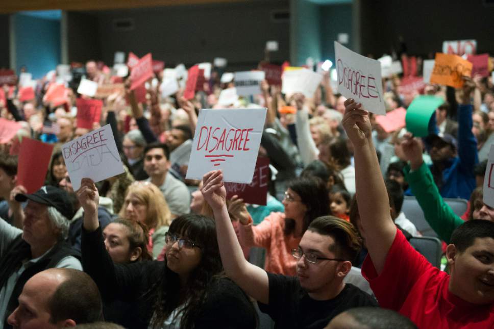 Chris Detrick  |  The Salt Lake Tribune
Members of the audience hold up signs at Rep. Chris Stewart during a town hall meeting at West High School Friday March 31, 2017.