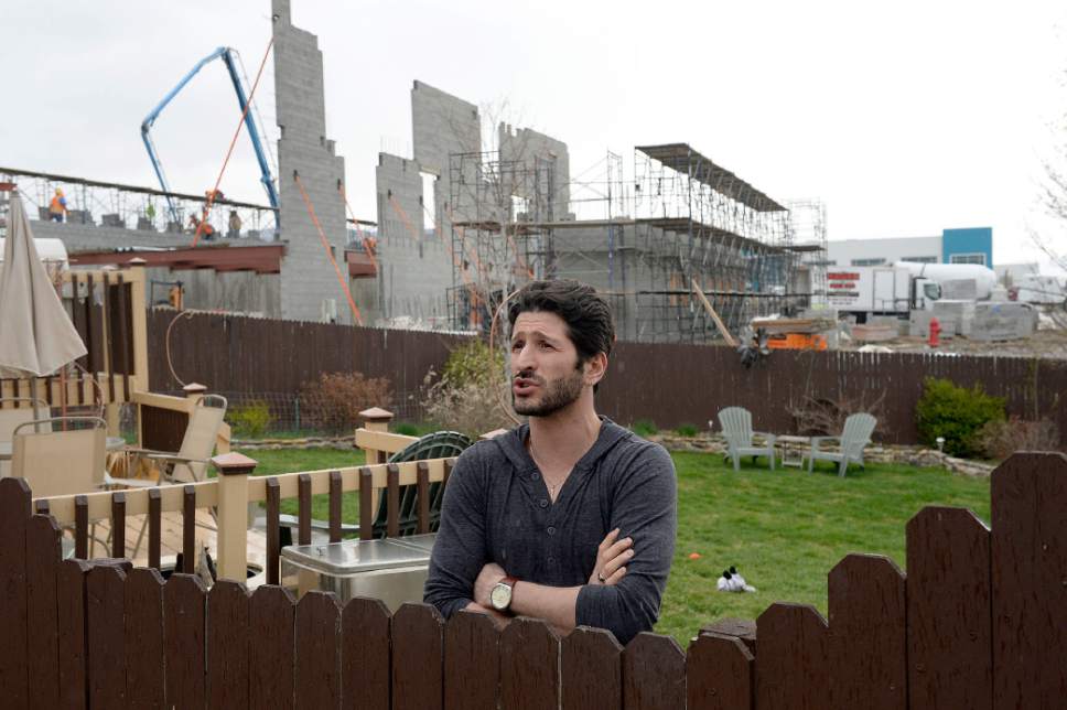 Al Hartmann  |  The Salt Lake Tribune
Travis Lucero who has lived in his home on Election Road in Draper is not happy at all with American Preparatory Academy's school expansion construction in his backyard.  The build up of the ground at the project is almost as high as his existing fence.  He is planning on selling along with other neighbors along the street.   APA has been told to halt construction of its new high school campus Thursday morning but workers were still on the job in the afternoon Thursday March 30.