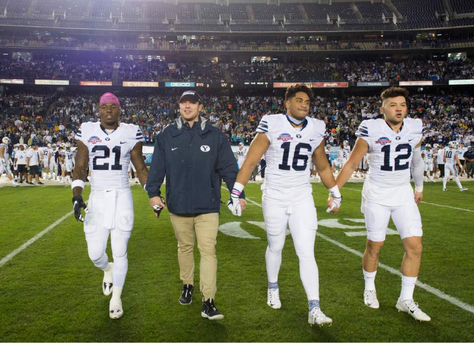 Rick Egan  |  The Salt Lake Tribune

Brigham Young Cougars running back Jamaal Williams (21) quarterback Taysom Hill, linebacker Harvey Langi (16), and quarterback Tanner Mangum (12) enter the field for the coin toss before the start of the Poinsettia Bowl, Brigham Young Cougars vs. Wyoming Cowboys at Qualcomm Stadium in San Diego, December 21, 2016.