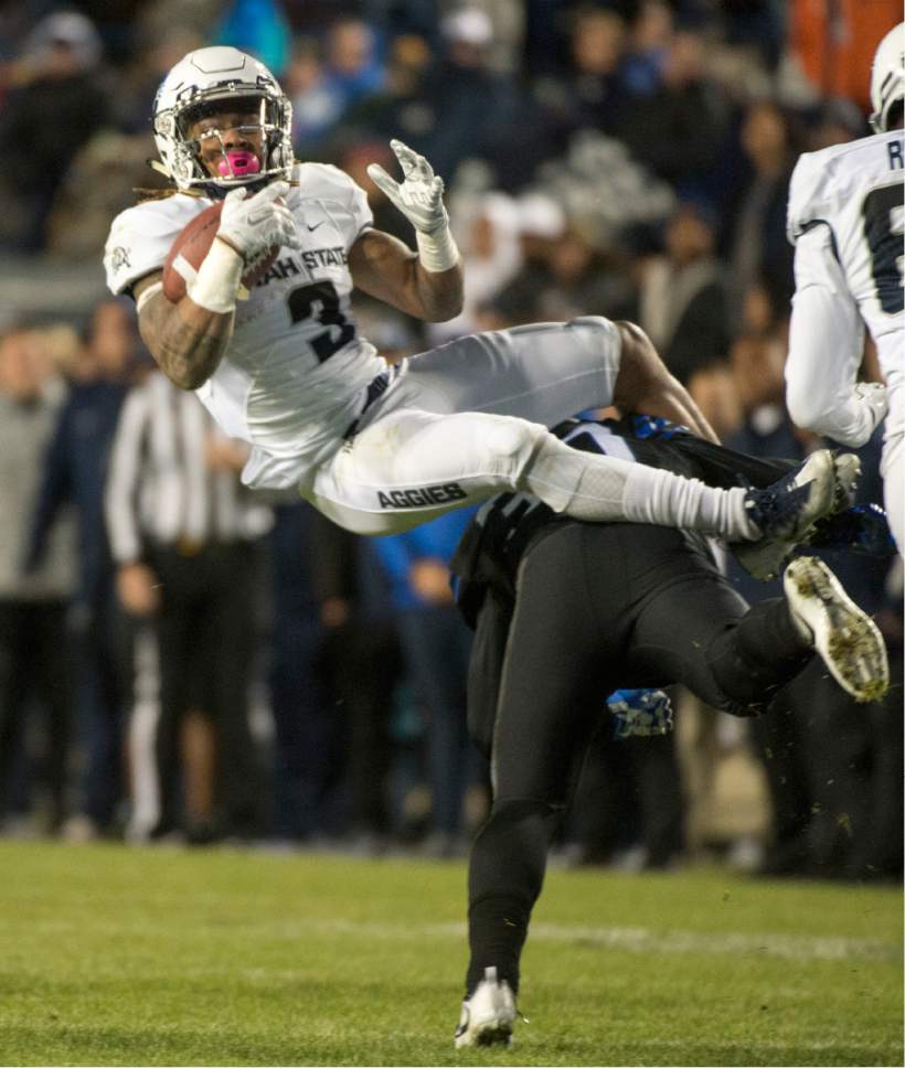 Rick Egan  |  The Salt Lake Tribune

Utah State Aggies safety Marquan Ellison (3 )gets tackled by Brigham Young Cougars defensive back Grant Jones (37), in football action, BYU vs Utah State, at Lavell Edwards Stadium in Provo,  Saturday, November 26, 2016.