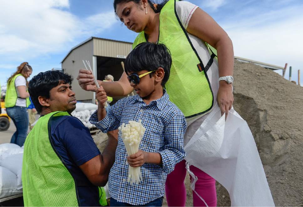 Francisco Kjolseth | The Salt Lake Tribune
Harsha Govindasamy, 5, performs a service project for his school as he is joined by his parents Govindasamy Jeyaramachandran, left, and Priya Ramalingam as they join other volunteers helping fill sandbags in anticipation of spring snowmelt at the Salt Lake County public works building in Midvale on Thursday, April 6, 2017.