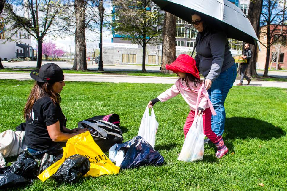Chris Detrick  |  The Salt Lake Tribune
Daisy Thomas and her daughter Tesla, 5, of Cottonwood Heights, hand out food to Ramona Delafuente at Pioneer Park Sunday, April 9, 2017.  Over thirty volunteers helped hand out 300 meals to homeless people around Pioneer Park and the Road Home.