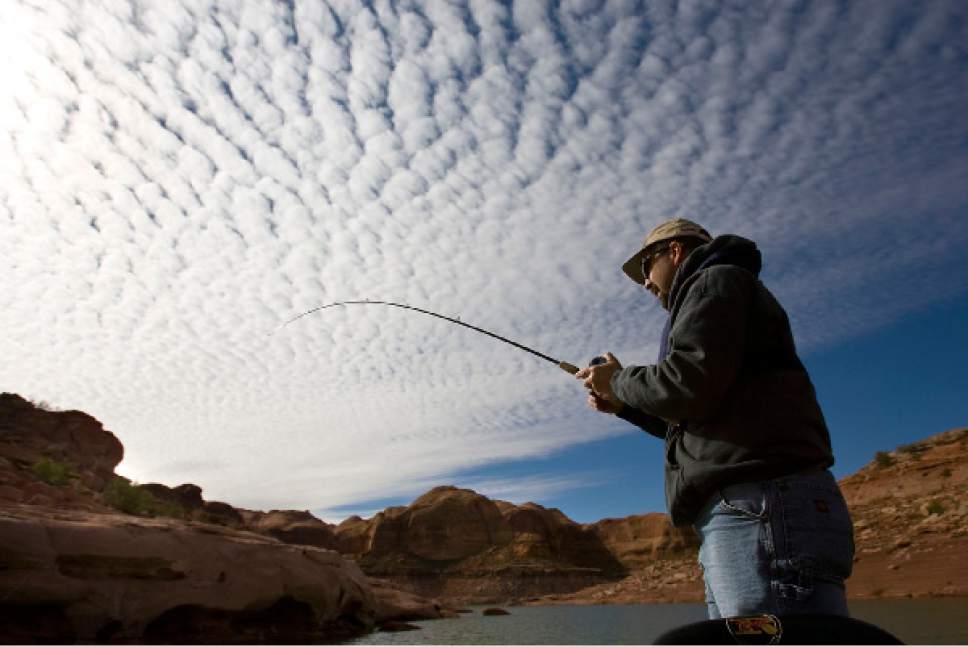 Al Hartmann  |  The Salt Lake Tribune
George Sommer fishes in Lake Powell's Good Hope Bay beneath a surrealistic morning sky in this 2015 file photo.