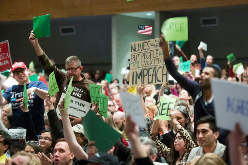 Chris Detrick  |  The Salt Lake Tribune
Members of the audience hold up signs while yelling and cheering at Rep. Chris Stewart during a town hall meeting at West High School Friday March 31, 2017.