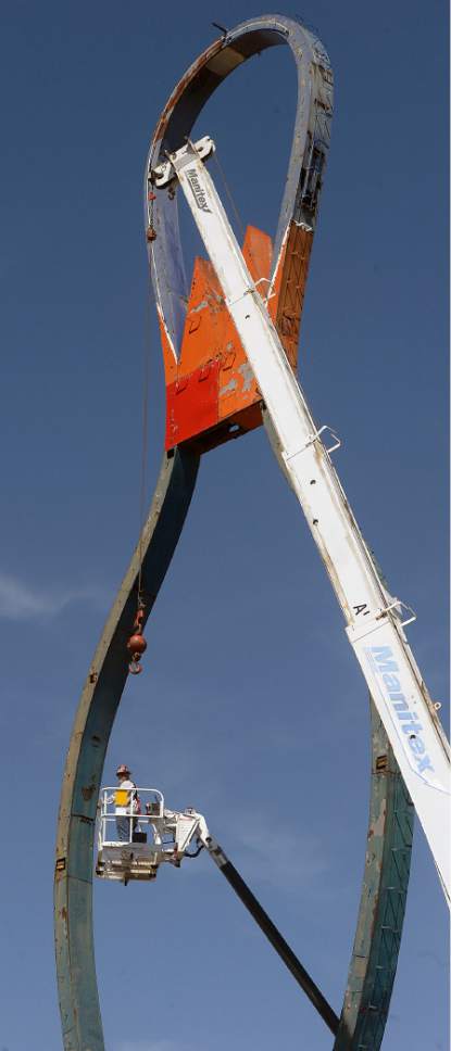 Al Hartmann  |  The Salt Lake Tribune
Yesco Sign Company's Mike Valdez on high lift begins to disassemble the metal frame of the iconic Ritz Classic Lanes sign at 2265 S. State St.  Wednesday April 12.  The job should take a couple days.  Not to worry.  After being taken apart it will renovated and put back up again.
