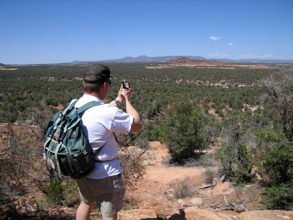 Al Hartmann  |  The Salt Lake Tribune 
Hiker takes a compass bearing before walking across part of Cedar Mesa in San Juan County.  Prominent Bears Ears formation visible in the distance. The area is included for a proposed Bears Ears National Monument.