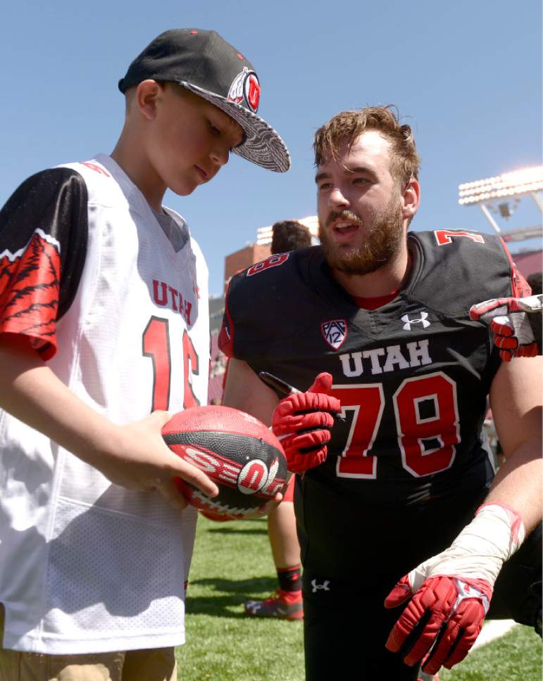 Leah Hogsten  |  The Salt Lake Tribune 
Kohen Cunningham gets an autograph from Jake Grant after the game. The University of Utah Utes were back in action  during the 16th-annual Red-White football game on Saturday, April 15, 2017 at  Rice-Eccles Stadium.
