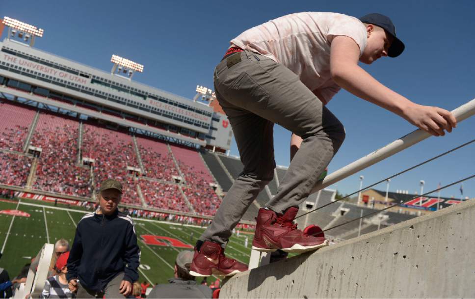 Leah Hogsten  |  The Salt Lake Tribune 
Broderick Evans takes the complicated way to get to his seat next to his father Brian at the start of the game. The University of Utah Utes were back in action  during the 16th-annual Red-White football game on Saturday, April 15, 2017 at  Rice-Eccles Stadium.