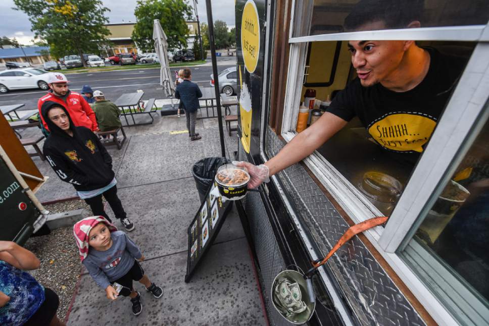 Francisco Kjolseth | The Salt Lake Tribune
Daniel Arellano serves an order from the Cupbop food truck. It's one of nearly 100 mobile food vendors in Utah that can be found through the new Food Truck League Finder app.