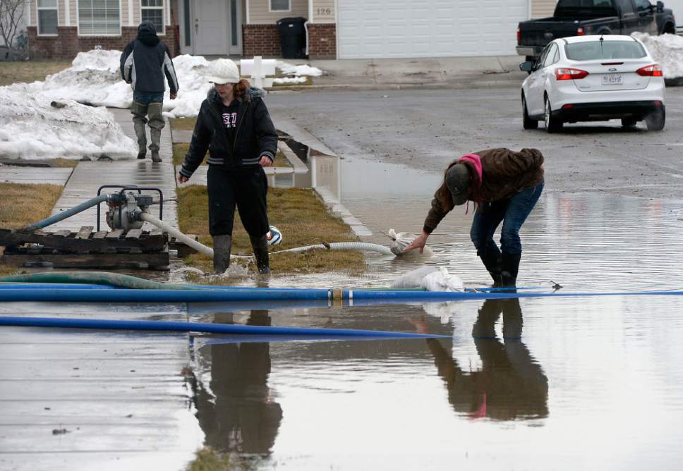 Al Hartmann  |  The Salt Lake Tribune
Amanda Mikesell, left, and her mother Vicki Summers man the pumps near 125 North 1650 West in Tremonton to pump standing water away from homes into the street in Feb. President Donald Trump on Friday declared that "a major disaster exists" in northern Utah after the region.