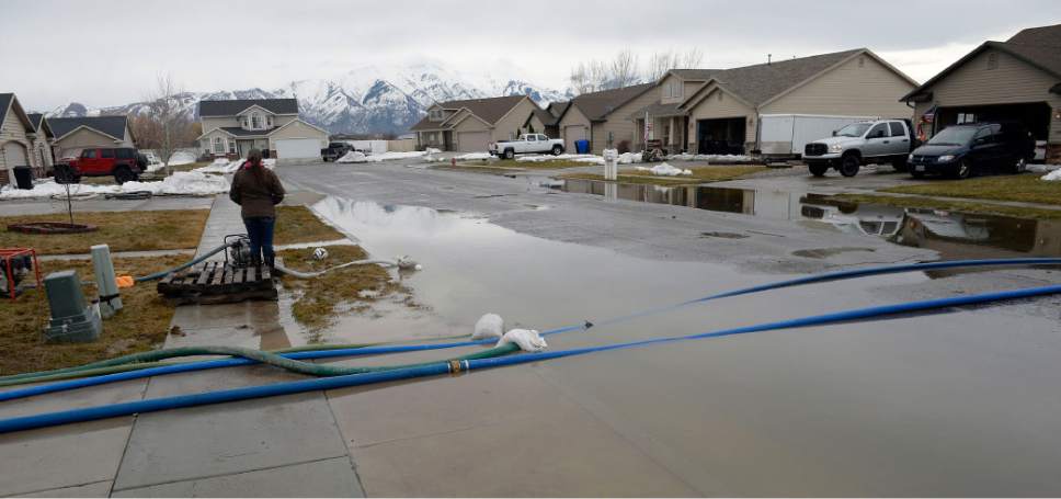 Al Hartmann  |  The Salt Lake Tribune
Residents of neighborhood near 125 North 1650 West in Tremonton pump standing water away from their homes into the street and a nearby retention pond Monday Feb. 20 before the next storm drops more rain.  Parts of Box Elder County have seen surface flooding from the rapid snow melt and rain over the weekend.  Luckily these homes do not have basements but water rose nearly to the front doors of some homes.  Main Street in Tremonton from 1000 to 2000 West was closed last night to pump out the area.