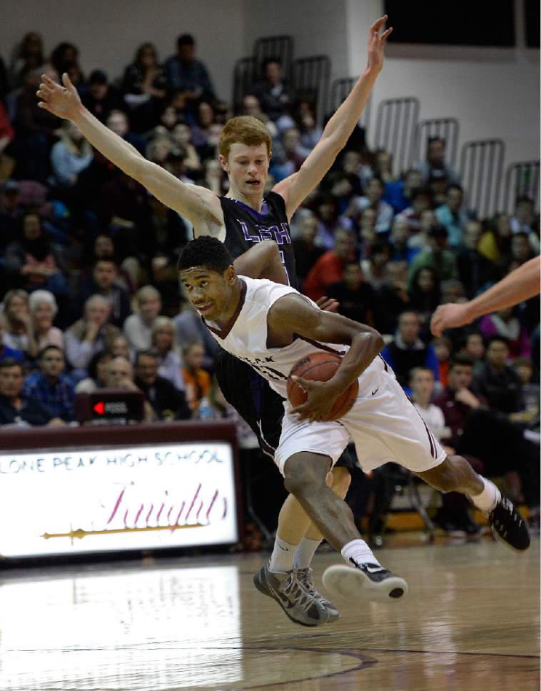 Scott Sommerdorf   |  The Salt Lake Tribune
Lone Peak's Christian Popoola drives through the defense of Lehi's Alex Pittard during first half play. Lone Peak held a 44-38 lead over Lehi at the half, and won 84-72, Friday, January 9, 2015.