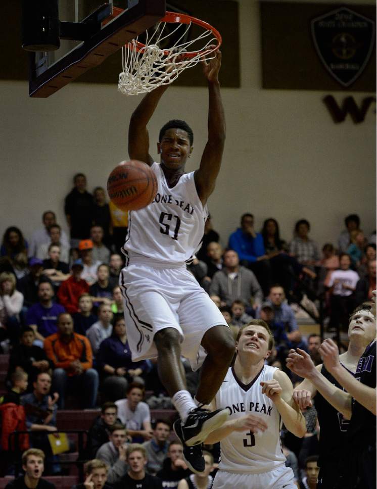 Scott Sommerdorf   |  The Salt Lake Tribune
Lone Peak's Christian Popoola dunks near the end of the half as Lone Peak stormed back into a game they trailed early. Lone Peak held a 44-38 lead over Lehi at the half, Friday, January 9, 2015.
