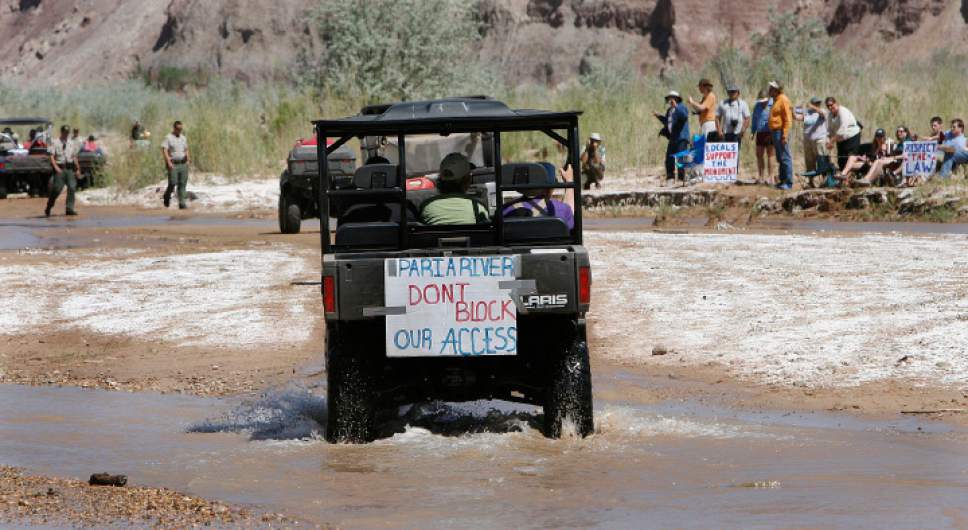 Scott Sommerdorf  |  The Salt Lake Tribune


With BLM agents on the left and anti-ATV protestors on the right, an ATV crosses the Paria Riverbed. ATV and off-road vehicle riders numbering just over 100 protested BLM road closures in Grand Staircase-Escalante National Monument and will gather to force their way onto federal land. They will be criss-crossing the Paria River. Saturday, 5/9/09.