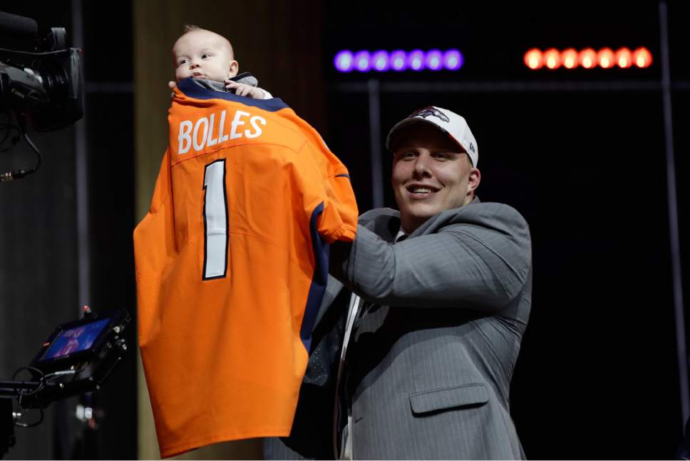 Utah's Garett Bolles, left, holds his son, Kingston, after being selected by the Denver Broncos during the first round of the 2017 NFL football draft, Thursday, April 27, 2017, in Philadelphia. (AP Photo/Matt Rourke)