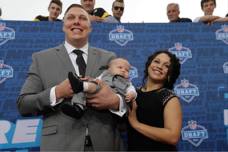 Utah's Garett Bolles arrives with his son Kingston and wife Natalie for the first round of the 2017 NFL football draft, Thursday, April 27, 2017, in Philadelphia. (AP Photo/Julio Cortez)