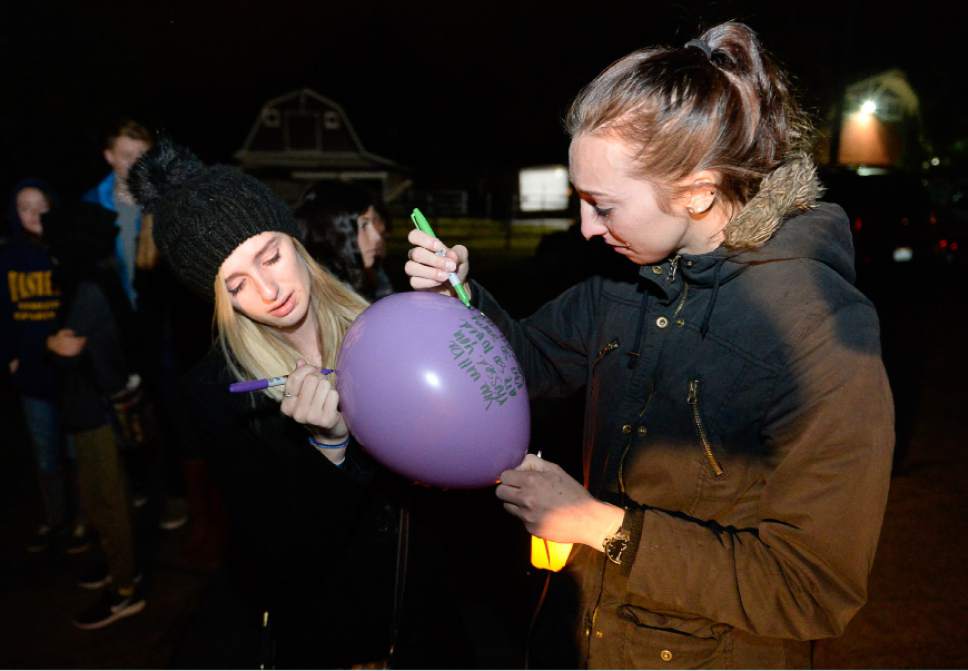 Francisco Kjolseth | The Salt Lake Tribune
Meg Warnock, left, and her sister Kate write a note on a balloon in remembrance of 16-year-olds Lexie Fenton and Ethan Fraga, during a vigil at Draper City Park on Sunday evening, Nov. 20, 2016. Three other teens who were in the vehicle were injured when the driver lost control of the car.