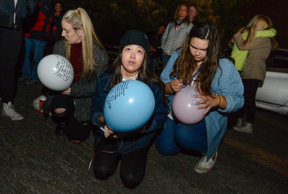 Francisco Kjolseth | The Salt Lake Tribune
Jayden Lewis, Shia Bergstrom and Katrina Price, from left, all 16-year-olds from Juan Diego High School, write personal notes on balloons before releasing them during a vigil at Draper City Park on Sunday evening, Nov. 20, 2016, in remembrance of teens Lexie Fenton and Ethan Fraga, both 16, who were killed in a single-car accident in Draper Saturday night. Three other teens who were in the vehicle were injured. All the teens were students at Corner Canyon High School.