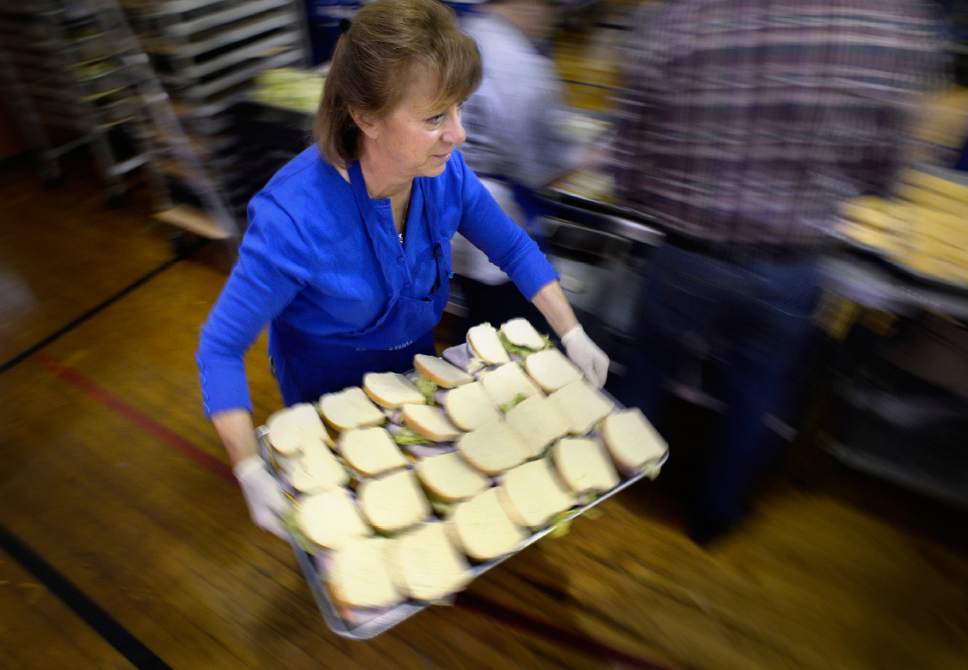 Scott Sommerdorf | The Salt Lake Tribune
Denise Vilven takes a tray of finished ham and cheese sandwiches to be bagged up as the Greek Orthodox Church of Greater Salt Lake prepared 3,500 sack lunches for area homeless shelters at the Hellenic Memorial Building, Saturday, April 29, 2017.