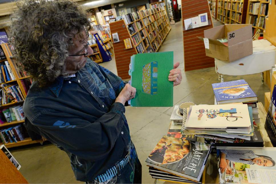 Francisco Kjolseth | The Salt Lake Tribune
Tony Weller, co-owner of Weller Book Works at Trolley Square, plans to pass along his "Bone Garb" spray-painted artistic stenciled expression onto customers who want something imprinted as part of Independent Bookstore Day on Saturday, April 29, 2017. As expected, a book is one of the options as he looks through some of the stencils he has created.