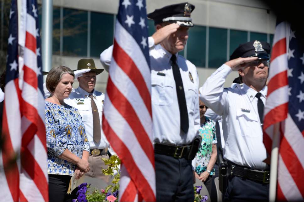 Scott Sommerdorf | The Salt Lake Tribune
Erika Barney, widow of Officer Doug Barney stands at left  as Sheriff Jim Winder, center, and Sergeant Jeff Evans salute during the presentation of the wreath during the Salt Lake County Sheriff's Office's annual memorial service hosted by the Salt Lake County Sheriff's Office Mutual Aid Association, Wednesday, May 3, 2017.