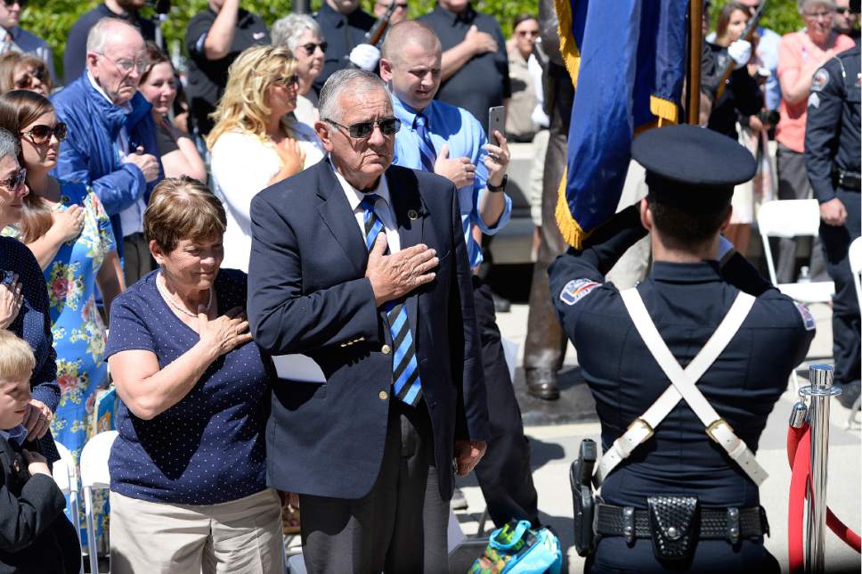 Scott Sommerdorf | The Salt Lake Tribune
Trooper Eric Ellsworth's parents Marjorie, left, and Ron Ellsworth, center, stand during the retrieval of the colors at the end of the annual Utah Law Enforcement Memorial ceremony, Thursday, May 4, 2017.