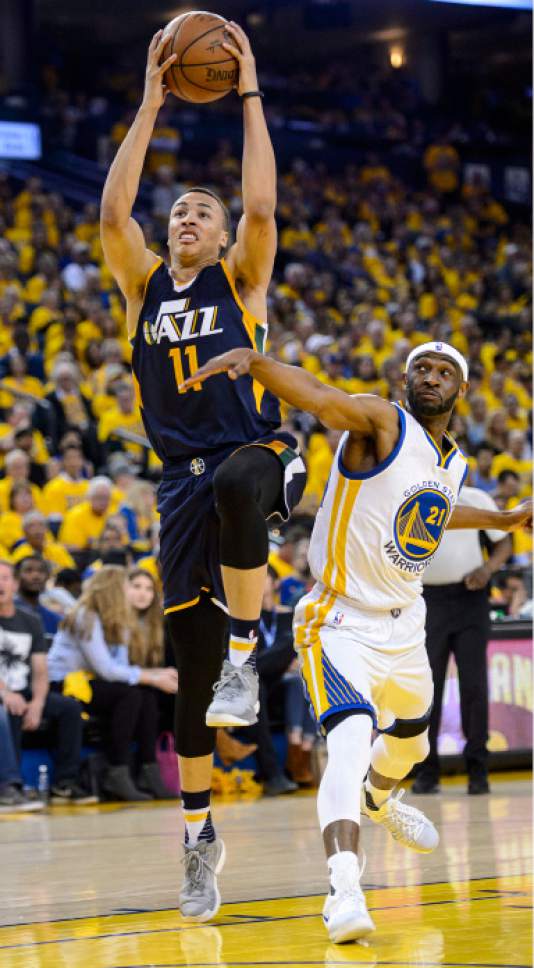 Steve Griffin  |  The Salt Lake Tribune
Utah Jazz guard Dante Exum (11) gets past Golden State Warriors guard Ian Clark (21) as he gets to the basket during Game 2 of the NBA playoff game between the Utah Jazz and the Golden State Warriors at Oracle Arena in Oakland on Thursday, May 4, 2017.