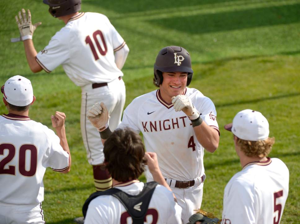 Leah Hogsten  |  The Salt Lake Tribune 
Lone Peak's Eli Norman celebrates his scoring run along with Payton Barney, two of six runs in the bottom of the sixth inning, to win the game. Lone Peak High School boys' baseball team defeated Pleasant Grove High School 8-5 during their game Monday, May 8, 2017.