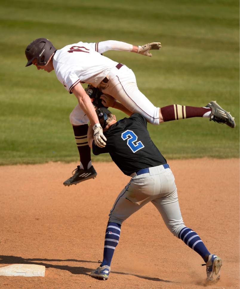 Leah Hogsten  |  The Salt Lake Tribune 
Lone Peak's Tyler MacPherson tries to leap over Pleasant Grove's Brock Watkins but is outed at second. Lone Peak High School boys' baseball team defeated Pleasant Grove High School 8-5 during their game Monday, May 8, 2017.