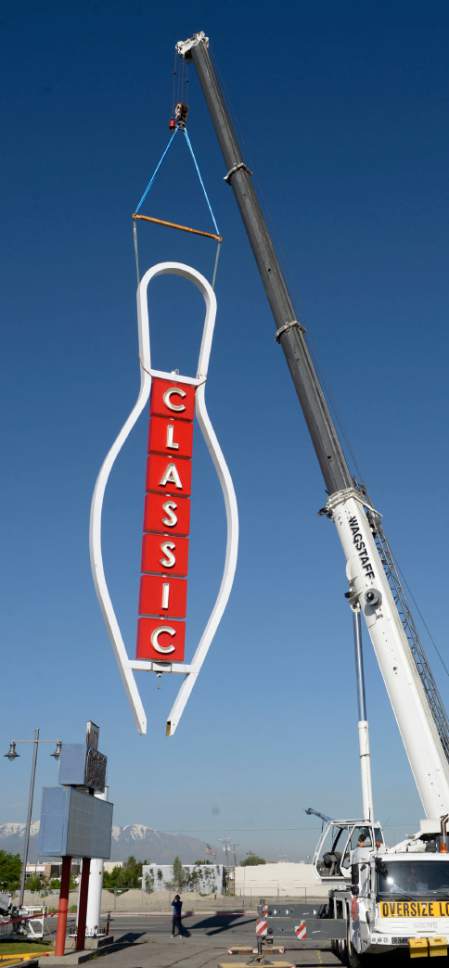 Al Hartmann  |  The Salt Lake Tribune
The 90-foot-tall iconic bowling pin sign rises again on State Street in South Salt Lake Tuesday May, 9. It was originally built in 1958 and was disassembled on April 12, 2017 for a complete renovation. Workers for Yesco Sign use a crane to ease it onto its base. 
It now will mark the entrance to the new Ritz Classic Apartments, under construction at 2265 S. State.