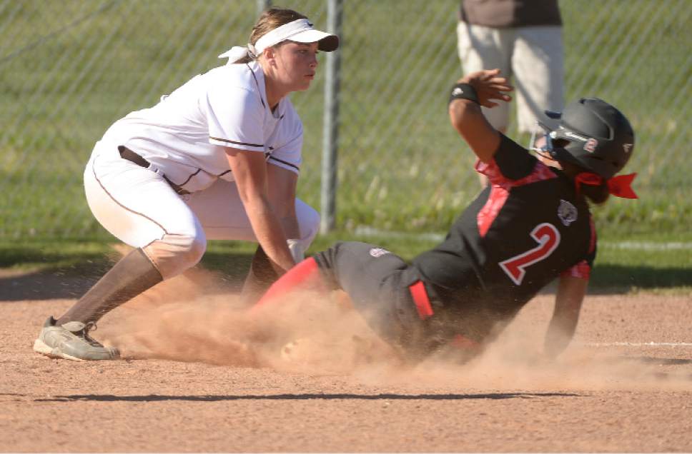 Leah Hogsten  |  The Salt Lake Tribune 
West's Keisha White slides safely into third before getting tagged by Davis'Mia Cullimore. West High School girls' softball team defeated Davis High School, 13-8, in Kaysville, Thursday, May 11, 2017.