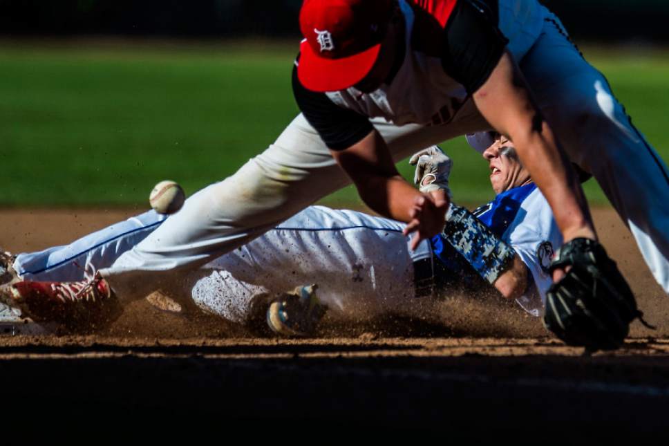 Chris Detrick  |  The Salt Lake Tribune
Gunnison Valley's Mason Bartholomew (14) slides safely into third base past Grand County's Christian Wilson (28)  during the Class 2A baseball state semifinal game at Kearns High School Friday, May 12, 2017.