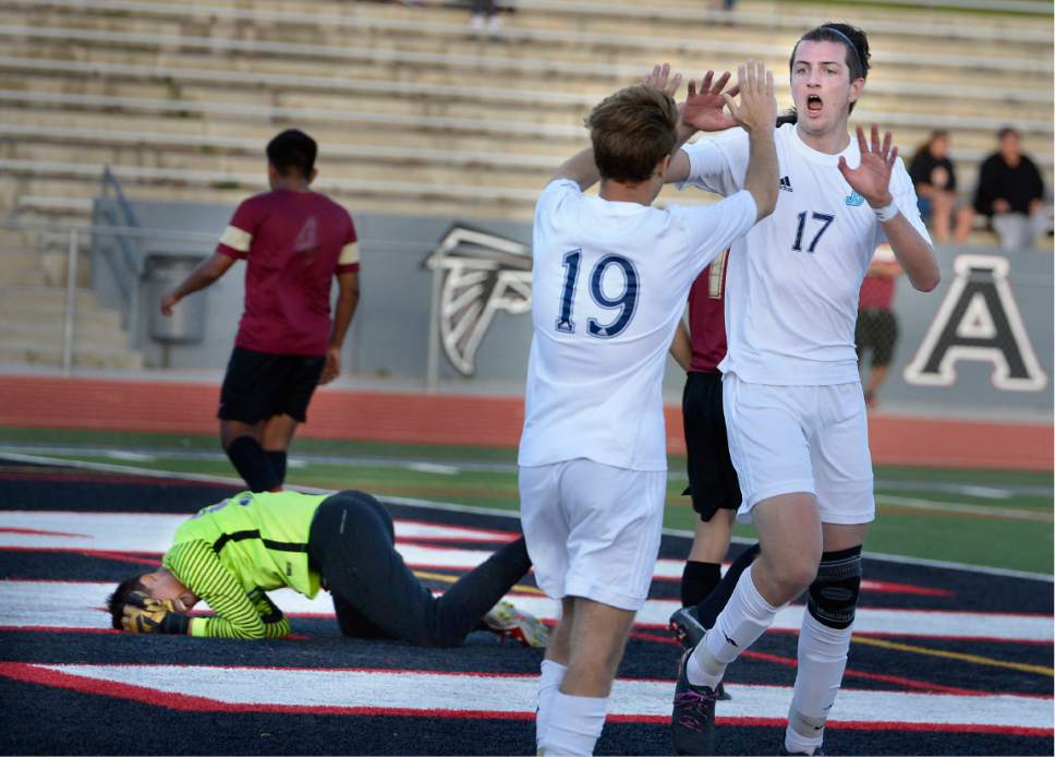 Scott Sommerdorf | The Salt Lake Tribune
Derek Stuercke, right, celebrates his goal with team mate Jared Mariani to give Juan Diego a 3-0 lead. The Logan goalkeeper Gabriel Guerrero writhes on the ground in pain at left. He was later removed and checked for a concussion. Juan Diego defeated Logan 3-1 in a 3A boy's semi-final, Friday, May 12, 2017.