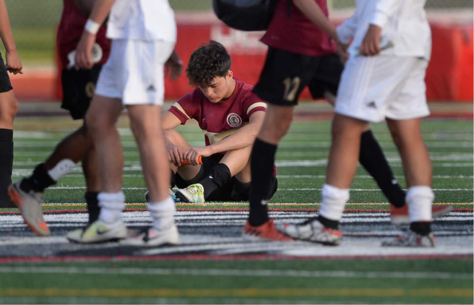 Scott Sommerdorf | The Salt Lake Tribune
Logan's Jonny Guardarrama sits dejectedly after the game as the rest of his team congratulates Juan Diego. Juan Diego defeated Logan 3-1 in a 3A boy's semi-final, Friday, May 12, 2017.