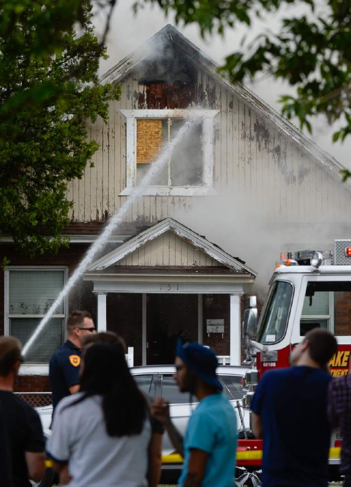 Francisco Kjolseth | The Salt Lake Tribune
People gather to watch as firefighters from across the city battle a two house fire at 900 W. 151 S. in Salt Lake City that sent smoke across the city on Monday, May 15, 2017.